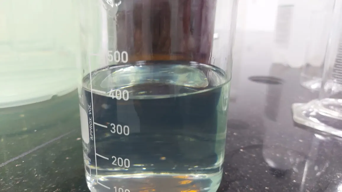 A 500 ml beaker of water-white naphtha on a black granite laboratory bench