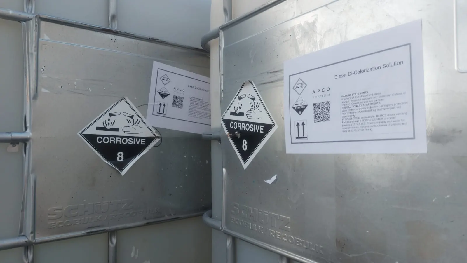IBC totes with corrosive labels and APCO product labels in the warehouse
