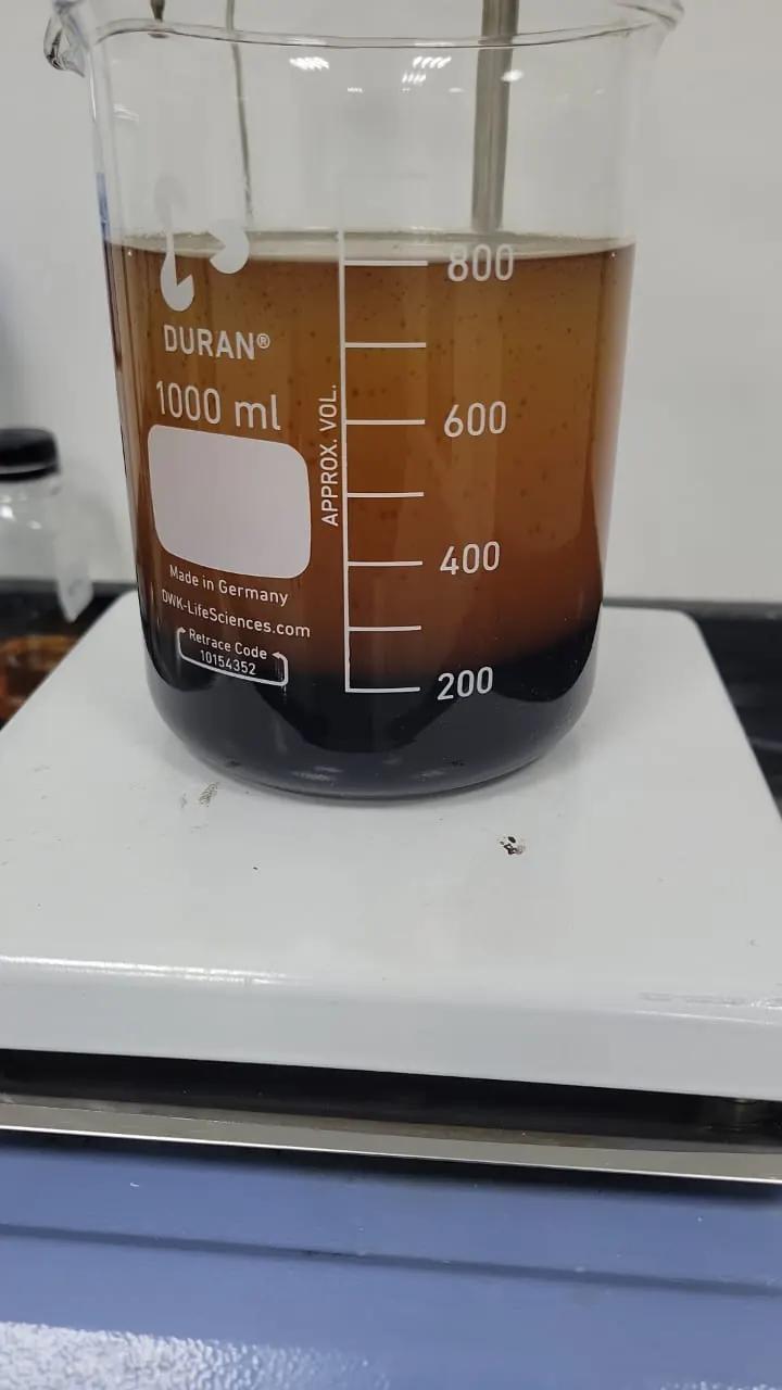 A 1,000 ml Duran beaker of dark fuel oil on a white magnetic stirrer plate